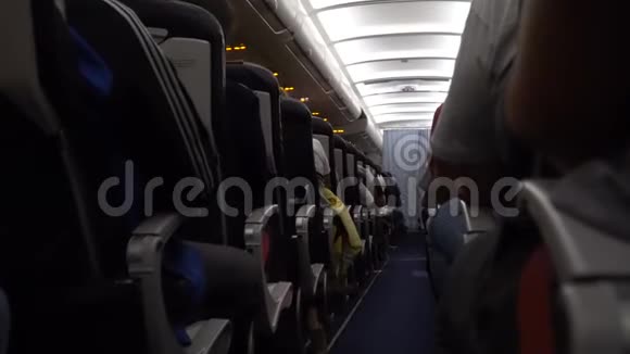 飞机内部乘客在飞行过程中在座位上过道上的椅子视频的预览图