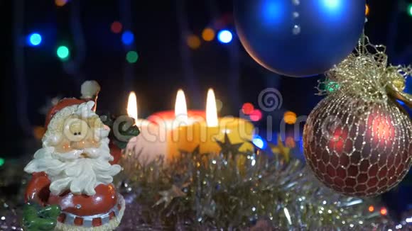 新年和圣诞装饰品燃烧蜡烛闪耀的加兰背景模糊漂亮的红球圣诞老人视频的预览图