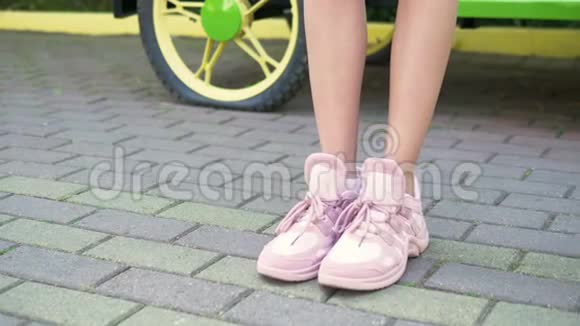 特写镜头女腿穿着时尚的粉红色运动鞋带着人行道走在街上的女孩自然阳光充足视频的预览图