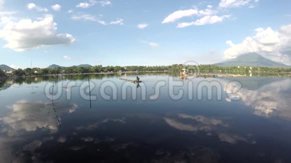 湖边船夫用竹筏划过山间湖视频的预览图