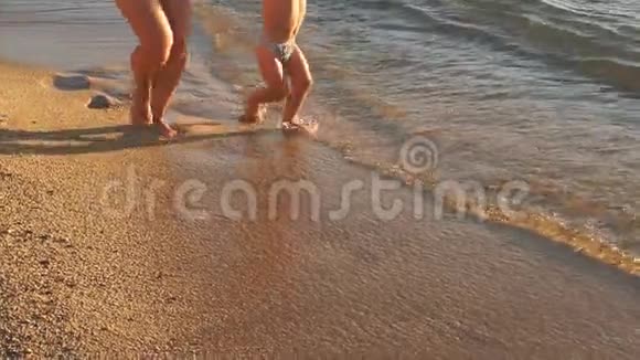 年轻的母亲和儿子在海滩上散步慢动作视频的预览图