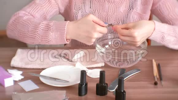 女人用尼珀切角质层自己修指甲特写双手手术工具放在桌子上视频的预览图