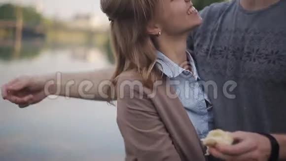 在这座城市的背景下在河边约会的情侣一个男人拥抱一个快乐的女孩视频的预览图