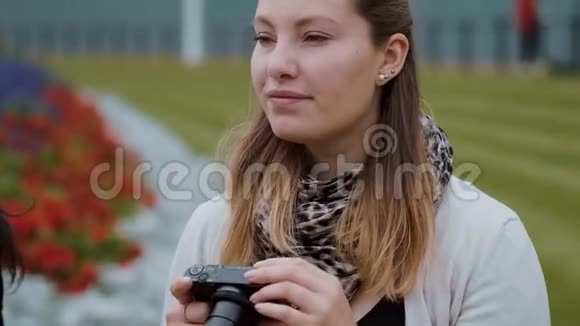 年轻女孩正在公园拍照视频的预览图
