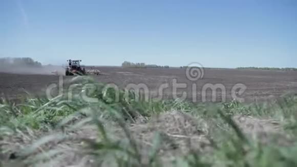实地工作一辆新拖拉机穿过一片新的田野在俄罗斯的某个地方农民们播种面包视频的预览图