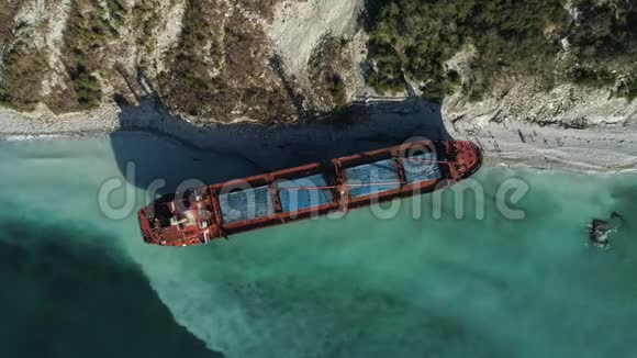 在美丽的蓝色海岸附近停泊着一艘空的红色的驳船一艘大工业飞船站在附近视频的预览图