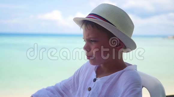 戴帽子的男孩从视野中眺望远处的大海和山脉看法视频的预览图