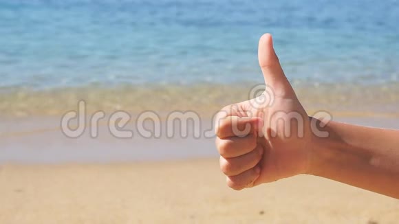 孩子在大海的背景上竖起大拇指视频的预览图