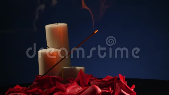 深色背景下有玫瑰花瓣的香枝和蜡烛视频的预览图