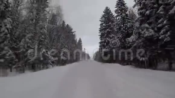 在暴风雪中驾驶在冬天的森林道路上汽车后视镜视频的预览图