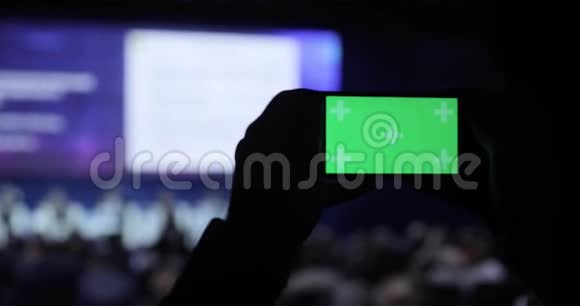 在会议上在移动智能手机上拍摄视频和照片的人绿色屏幕与卢马哑光包括在内商务视频的预览图