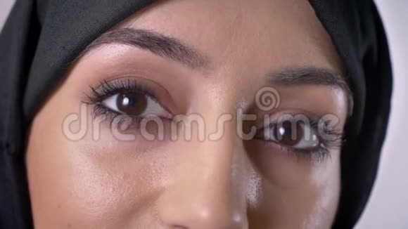 戴着头巾的穆斯林女孩正在镜头前观看灰色背景视频的预览图