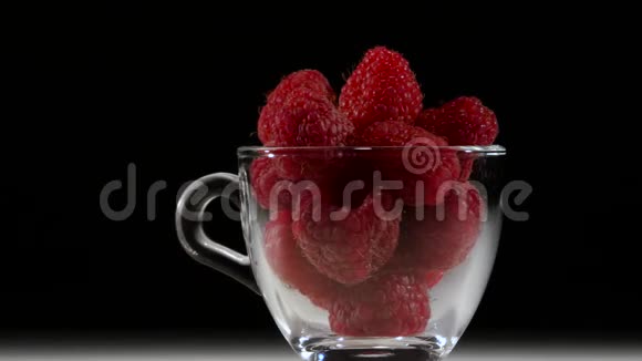 透明杯中的维生素树莓甜点在黑色背景上旋转关门视频的预览图