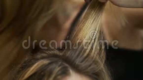 在金发发夹上的特写沙龙Naches为Hairstyle提供温暖视频的预览图