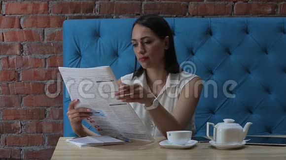 年轻女子在餐馆里喝杯咖啡看报纸视频的预览图