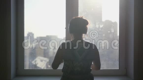 女孩打开窗户从窗户欣赏城市景色慢动作1920x1080视频的预览图