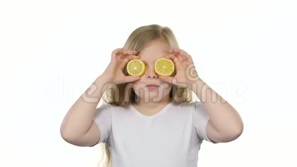 小女孩用柠檬闭上眼睛表现出不同的情绪舔它和呱呱叫白色背景视频的预览图