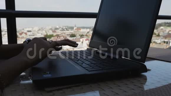 女人年轻的手在手提电脑键盘上工作视频的预览图