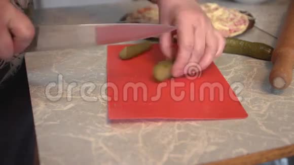 女人手把腌制好的黄瓜切成薄片准备披萨视频的预览图