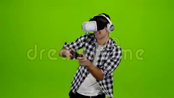 男人带着耳机和虚拟现实眼镜玩游戏视频的预览图