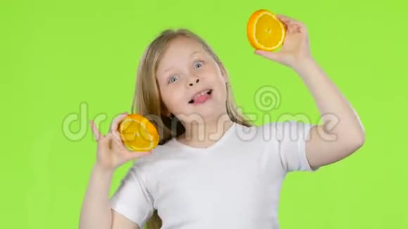 小女孩拿着一个橙色的切片闭上眼睛和曲线绿色屏幕视频的预览图