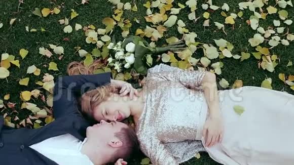 婚礼的主题新娘和新郎都在枫叶的草地上视频的预览图