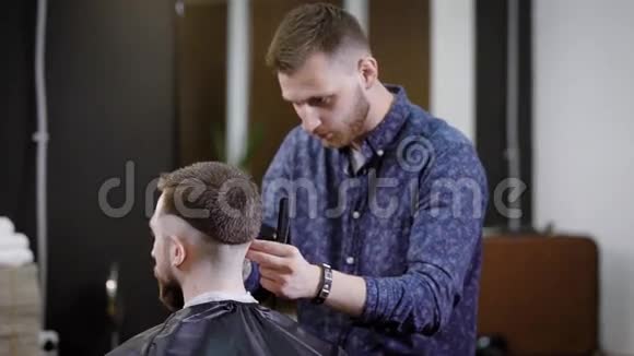 理发店里坐在椅子上的理发师给无法辨认的男性客户做时尚发型视频的预览图