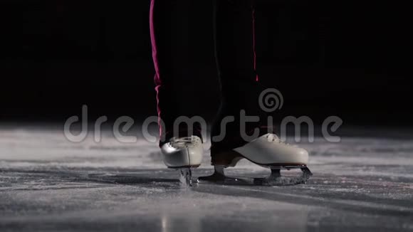 特写双腿穿着冰鞋走到冰上在框架中移动镜头在溜冰鞋后面动态移动视频的预览图