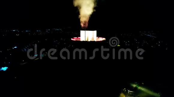 迷人的空中无人机4k在能源电站塔上的视野在漆黑的夜空中产生明亮的彩色烟雾视频的预览图