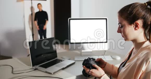 女摄影师在摄影棚里用数码相机拍摄照片视频的预览图