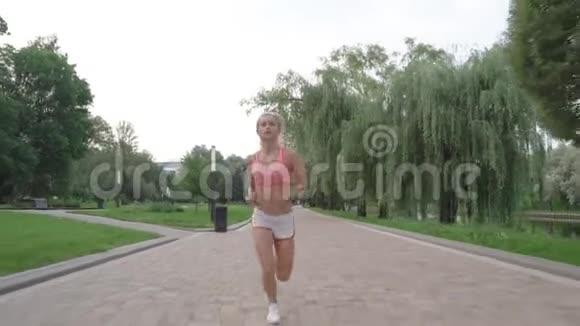 日出时英俊的女人在公园里奔跑的肖像视频的预览图