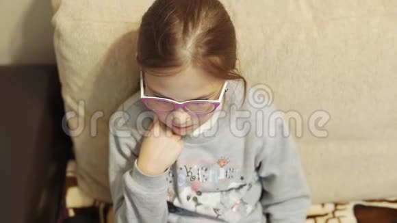 一个戴着粉色眼镜手提电脑的女孩坐在家里的沙发上视频的预览图