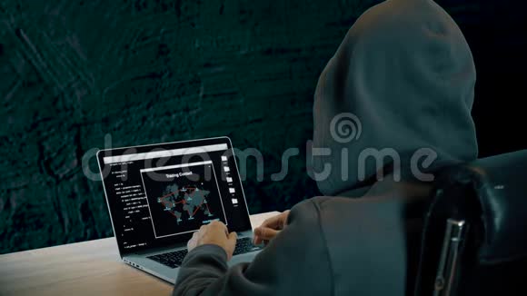笔记本电脑上的黑客追踪联系一个头戴帽子的人坐在黑暗的夜晚笔记本电脑屏幕的肩膀视频的预览图