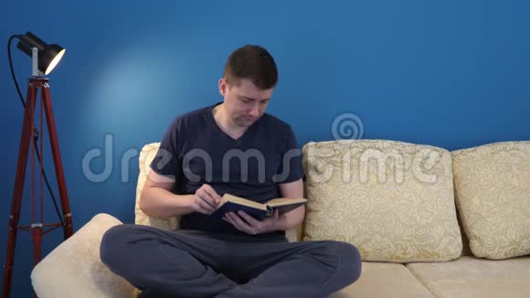 男人坐在沙发上看书视频的预览图