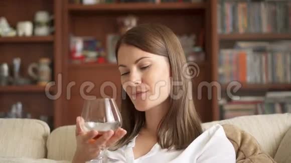慢动作女人在家享受舒适的夜晚独自喝着白兰地白兰地白兰地视频的预览图