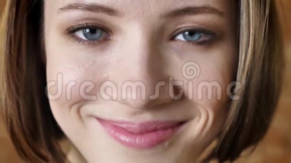 年轻迷人的害羞女孩的脸在微笑看着镜头砖背景视频的预览图