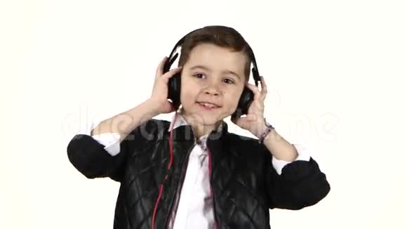 小男孩用耳机听音乐跳舞特写视频的预览图