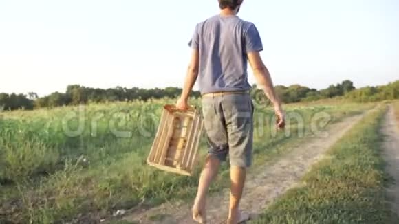 年轻的农民带着空木箱去田间收割玉米视频的预览图