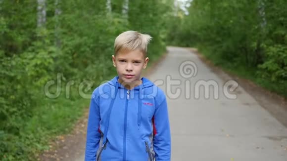 一个漂亮的孩子正沿着公园的小巷走户外活动视频的预览图