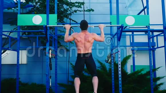 肌肉男在运动场的横杆上拉起来视频的预览图