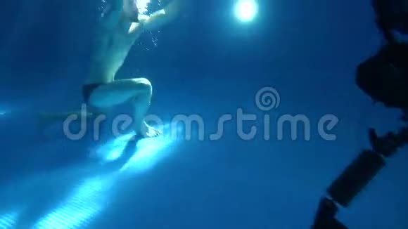 为这些场景表演一个年轻人翻筋斗在水下翻筋斗他在镜头前摆姿势视频的预览图
