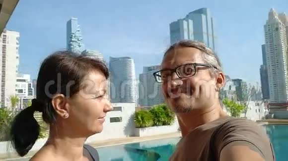 微笑情侣在摩天大楼背景下自拍视频的预览图