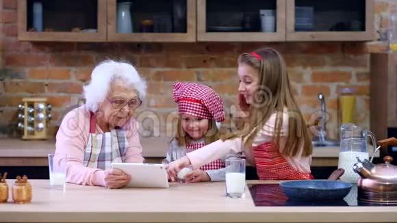 孙女和奶奶带着平板电脑在厨房视频的预览图