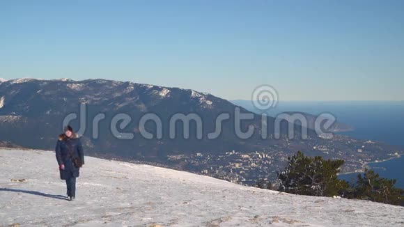 女走上白雪皑皑的高山高原视频的预览图