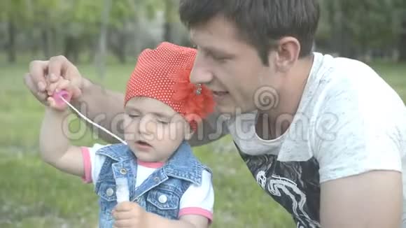 爸爸在公园里和漂亮的小女儿玩热爱家庭观念视频的预览图