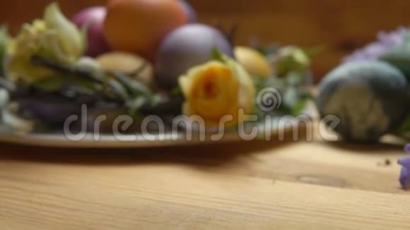 在复活节彩蛋的背景下一朵黄色玫瑰花瓣落在桌子上视频的预览图