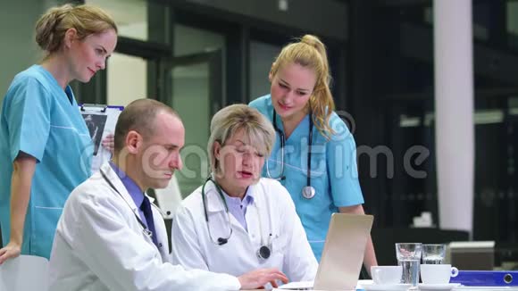 医生和护士在会议室讨论笔记本电脑视频的预览图