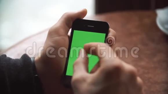 男性手使用智能手机与绿色屏幕在咖啡厅视频的预览图