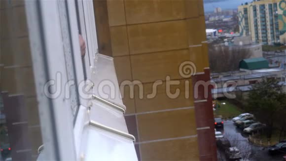 一个人从公寓窗户的锅里倒水视频的预览图