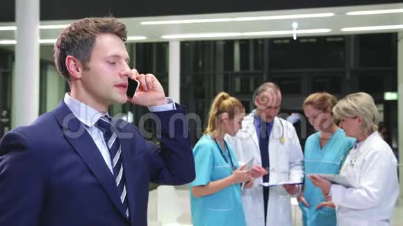 商人在医院走廊里用手机说话视频的预览图